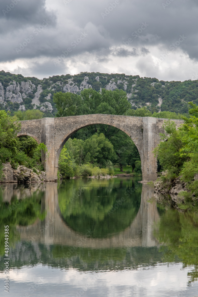 View of the river Herault in the South of France with the bridge of Saint Etienne d'Issensac in the background