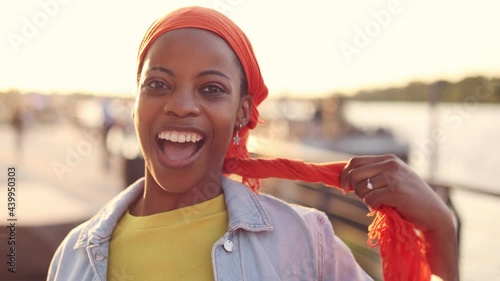 Beautiful young woman putting on head wrap
 photo