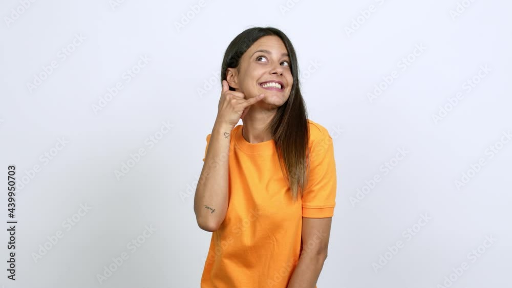 Young woman making phone gesture and speaking with someone. Call me back sign over isolated background Young woman making phone gesture and speaking with someone. Call me back sign over isolated background