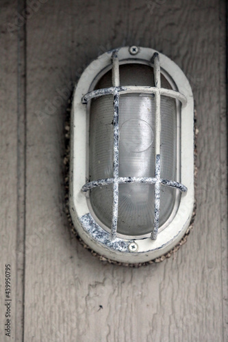rustic outdoor light with white trim on a tan building