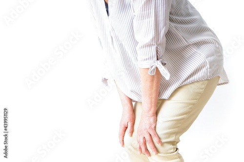 膝の痛みを感じる高齢者の女性
