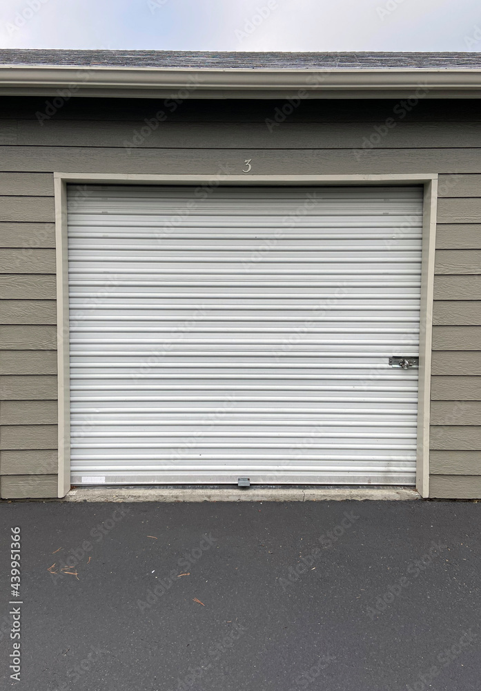 White garage doors with numbers on buildings with tan siding White garage doors with numbers on buildings with tan siding