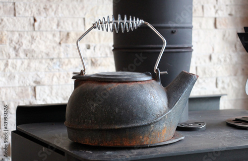 Old black iron kettle on a woodstove