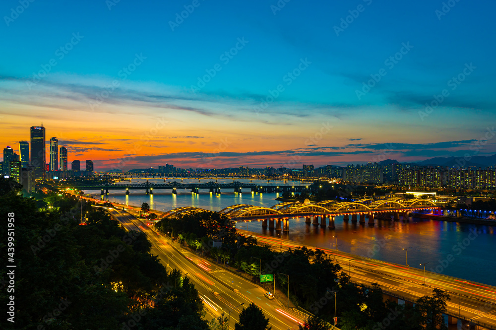 Obraz premium top view of seoul Downtown Skyline with traffic on bridge at han river. south korea. Financial district and business centers in smart urban city in Asia. Skyscraper and high-rise buildings at sunset.