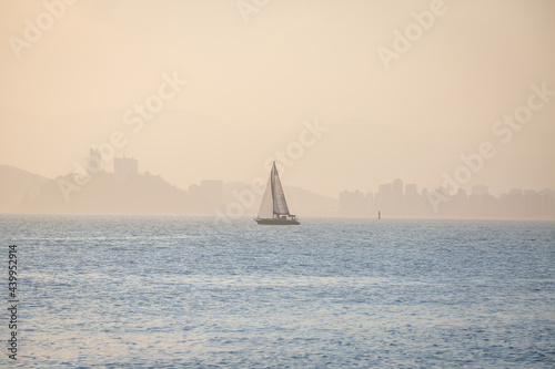 Sailboat sailing in the bay of Santos, Brazil, in a foggy and sunny day