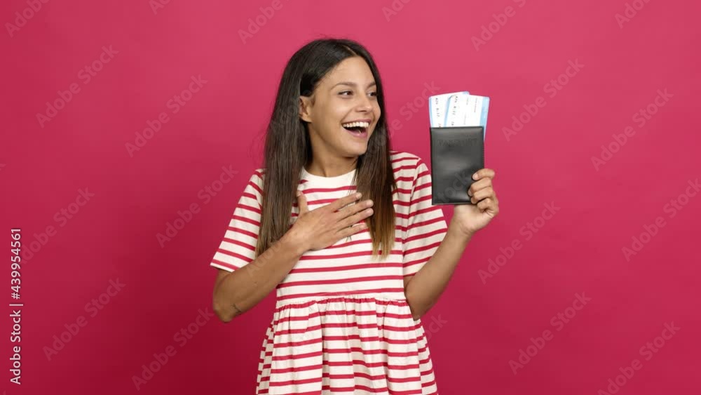 Young woman holding a passport and doing surprise gesture over isolated background Young woman holding a passport and doing surprise gesture over isolated background