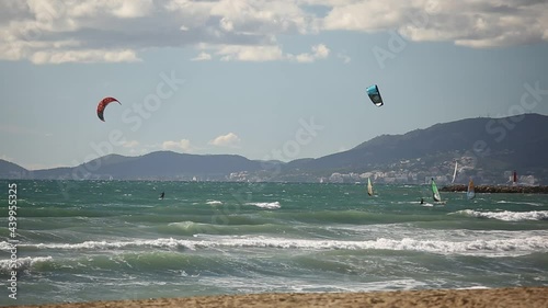 Extreme water sports, people are kitesurfing in the ocean near the beach, Spain