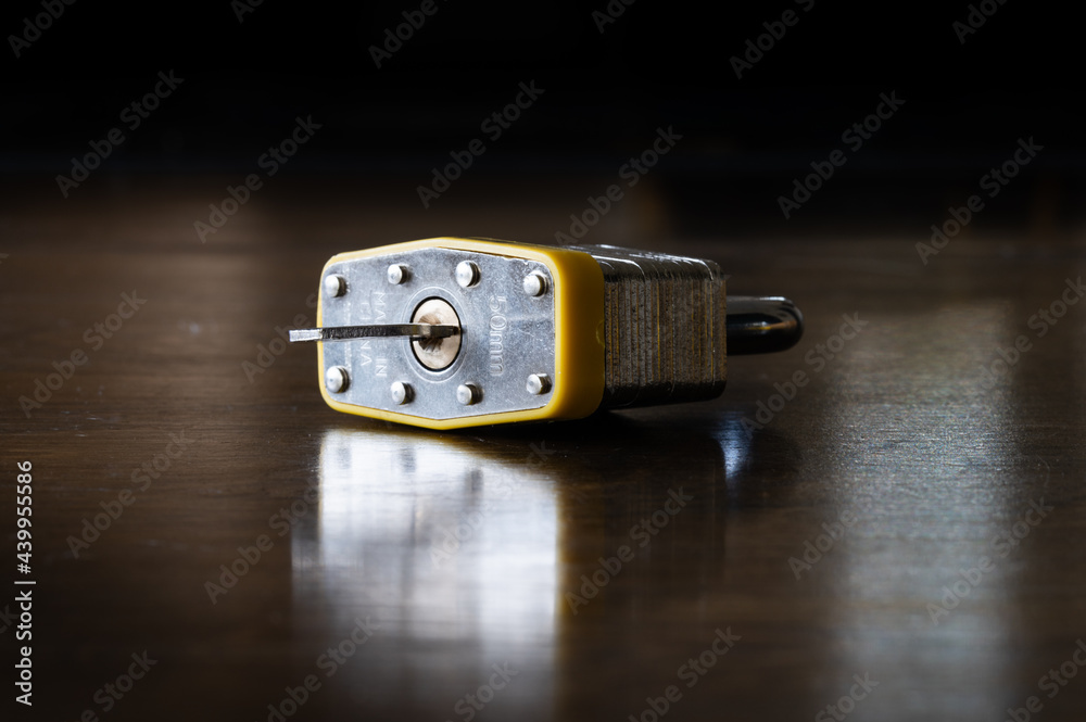 Padlock with Key Sitting on a Wood Table Padlock with Key Sitting on a Wood Table