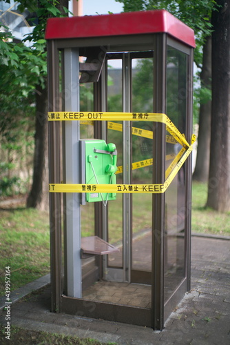 Tokyo,Japan-June 15, 2021: Keep Out Barricade taped telephone booth, ordered by Metropolitan Police Department in Tokyo, Japan.   © Khun Ta