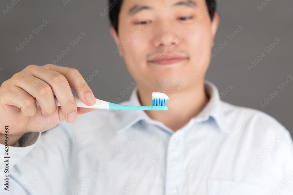 Man holding toothbrush with squeezed toothpaste ready to brush Man holding toothbrush with squeezed toothpaste ready to brush