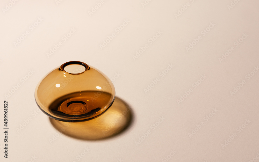 Empty glass vase on beige background with hard long shadows with copy space, horizontal Empty glass vase on beige background with hard long shadows with copy space, horizontal