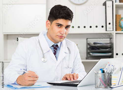 Physician is doing report about patients in hospital.