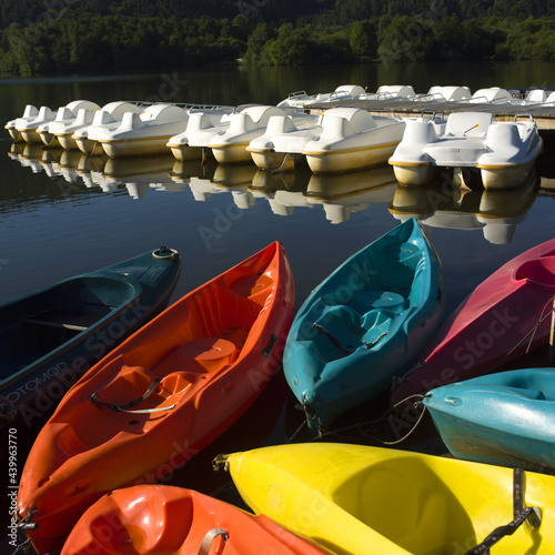 Rows of pedalos for rent along a wooden pontoon, Lake Chambon, Puy de Dome, Auvergne, France photo