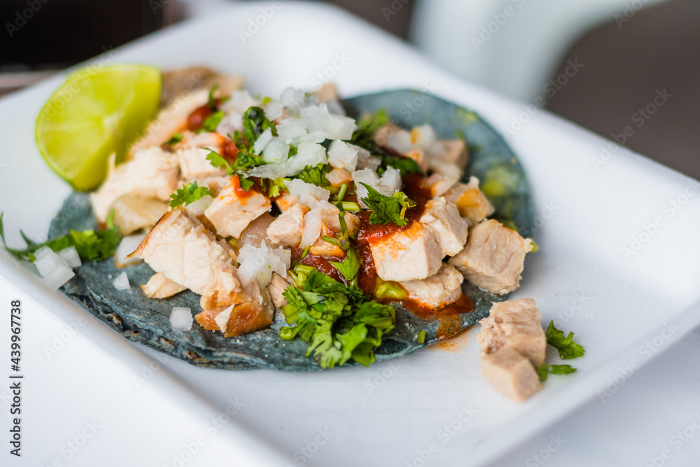 Mexican Carnitas taco with cilantro and onion blue corn tortilla and lemon. Mexican Carnitas taco with cilantro and onion blue corn tortilla and lemon.