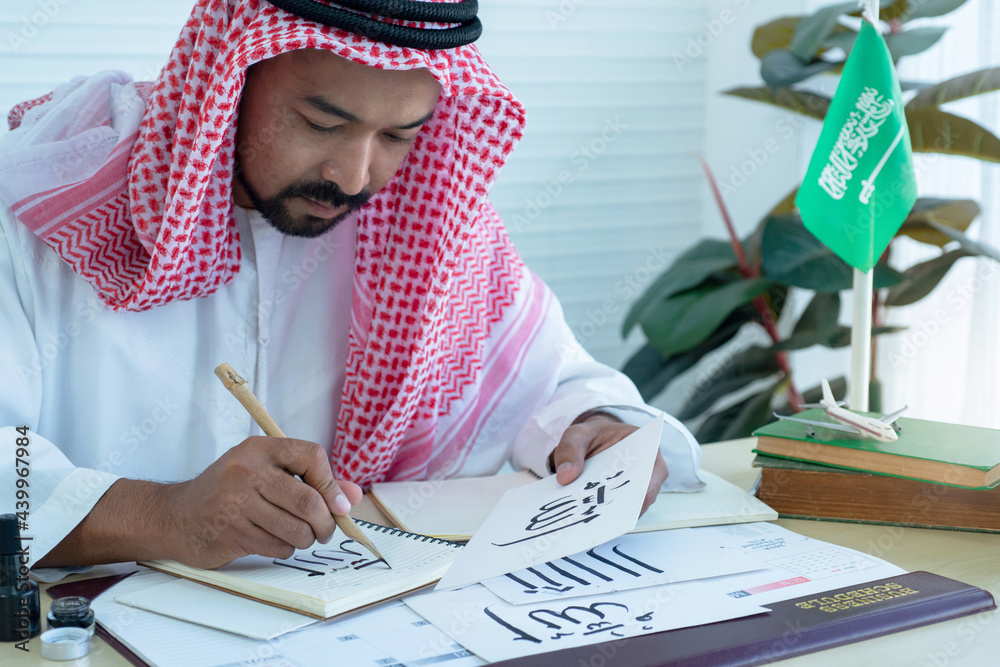 Arab men practicing writing Arabic with bamboo pens and ink on paper