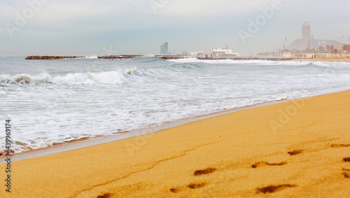 Sea view and city view from the coastal strip of the Mediterranean Sea with a sandy beach in the area of San Martí in Barcelona, Spain