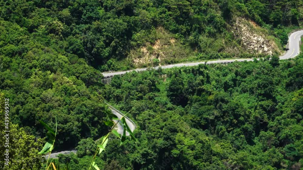 Vehicles traveling on the mountain forest road in the country side. Driving along the wild mountain forest road. View on the highway through the jungle. Driving in the winding road, Phan Rang, DaLat. Vehicles traveling on the mountain forest road in the country side. Driving along the wild mountain forest road. View on the highway through the jungle. Driving in the winding road, Phan Rang, DaLat.