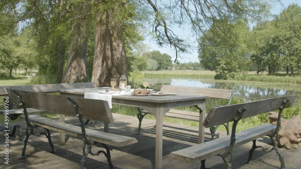 Delicious breakfast set up on table in the countryside near pond - wide Delicious breakfast set up on table in the countryside near pond - wide