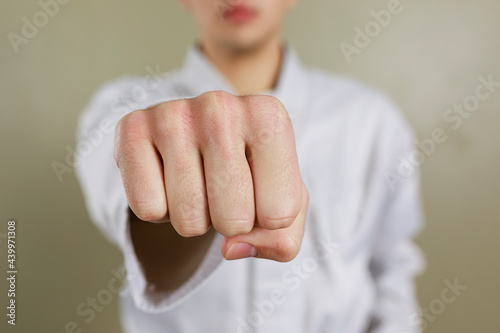 Close up shot of man's hand with clenched fist extended towards camera.