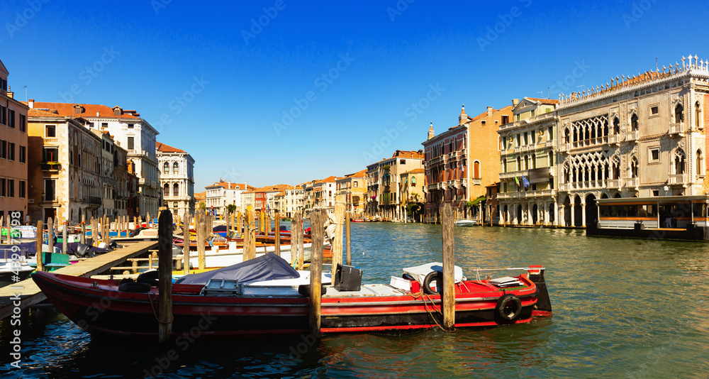 Motor boats parking in Grand Canal in Venice on background of impressive architecture of ancient buildings on banks of canal