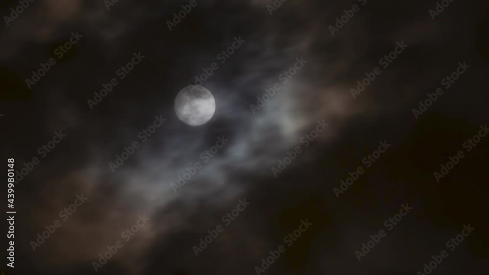 Brightly Lit Full Moon Timelapse Moving Out of Frame in Sky with Thick Clouds Swiftly Passing on Stormy Night Brightly Lit Full Moon Timelapse Moving Out of Frame in Sky with Thick Clouds Swiftly Passing on Stormy Night