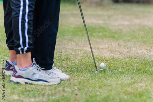 Asian young father support teaching training daughter to play perfect golf while standing in the game of golf together in nature a field garden park, family outdoors sport concept