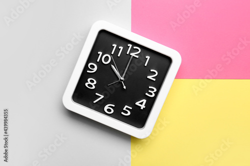 Stylish clock on color background