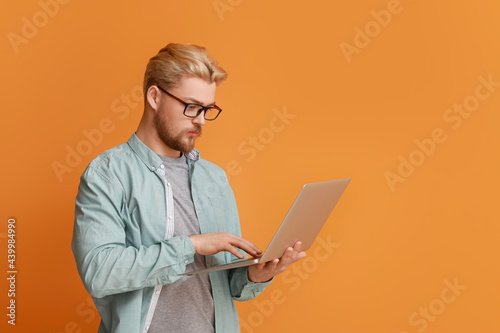 Handsome man using laptop o...