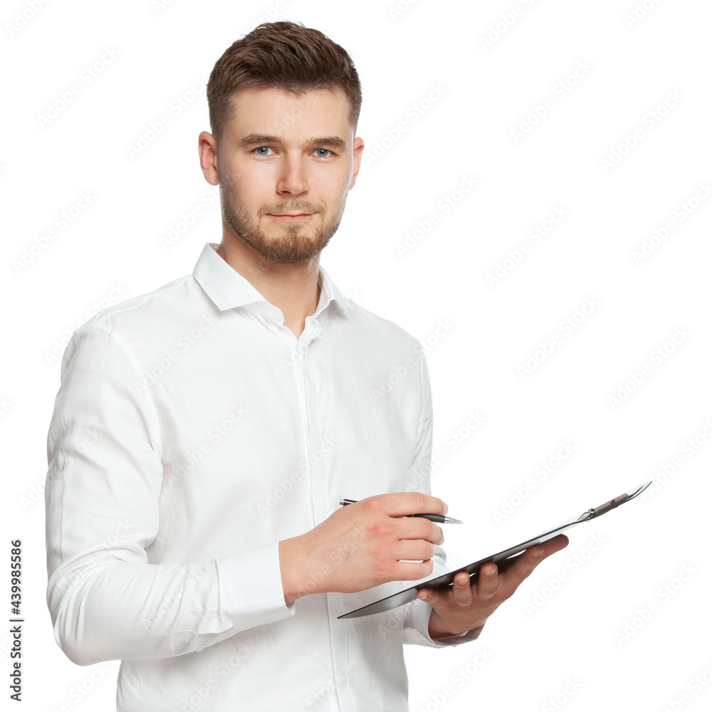 Portrait of a young man in a white shirt with a notebook and a pen in his hands communicates with the client, makes notes and looks into the frame. The figure is isolated on a white background. Portrait of a young man in a white shirt with a notebook and a pen in his hands communicates with the client, makes notes and looks into the frame. The figure is isolated on a white background.