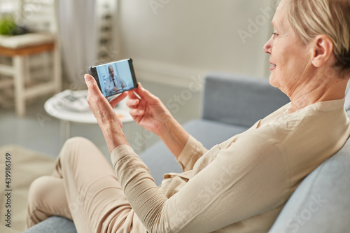 Sick woman during a video call with a doctor. Side view of patient talking during conference call with his doctor while at home