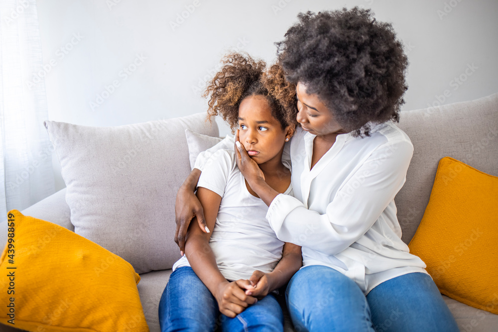 Focus on upset sad small daughter sitting on sofa with mother, mom scold kid for bad behaviour, child psychologist help girl deal with emotional social behavior problems trauma therapy support concept Focus on upset sad small daughter sitting on sofa with mother, mom scold kid for bad behaviour, child psychologist help girl deal with emotional social behavior problems trauma therapy support concept