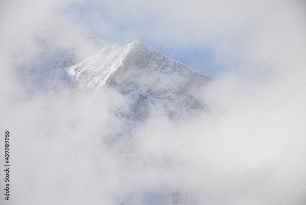 Mountain peak covered by snow in the clouds. Mountain peak covered by snow in the clouds.