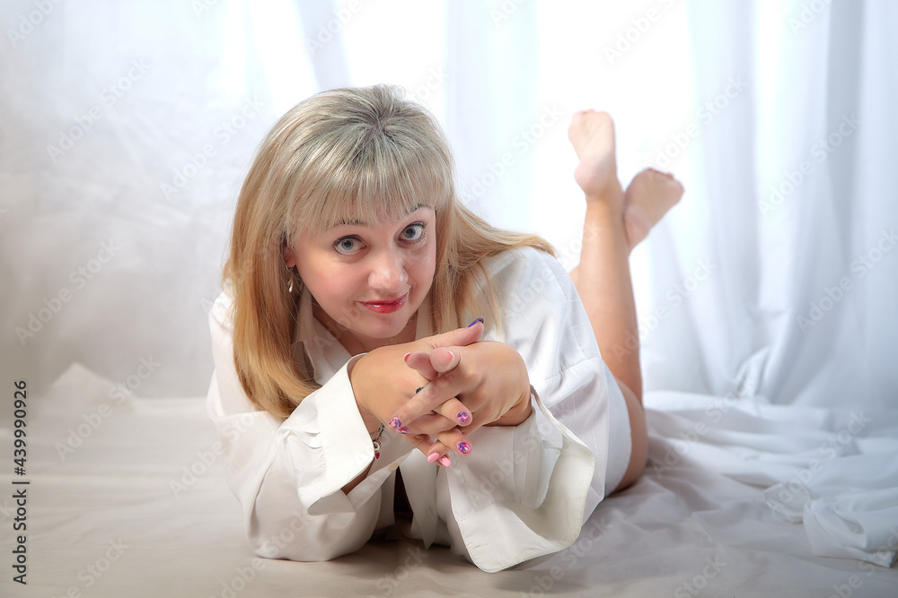 Beautiful female model with blonde long hair posing in studio on a white background in nice dress Beautiful female model with blonde long hair posing in studio on a white background in nice dress