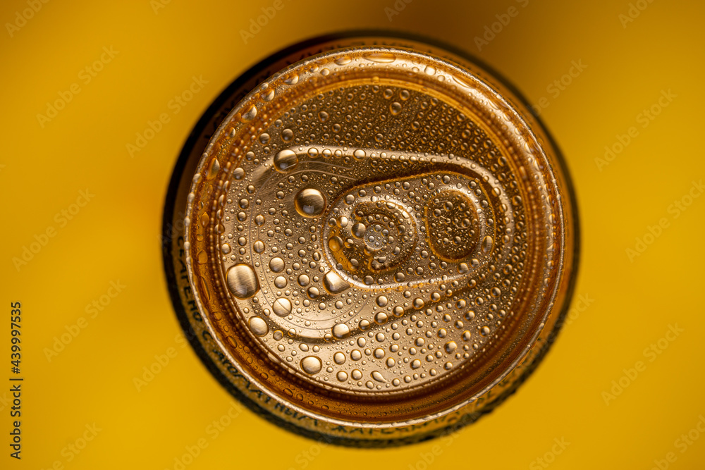 condensation on a cold metal beer can on a yellow background. top view condensation on a cold metal beer can on a yellow background. top view