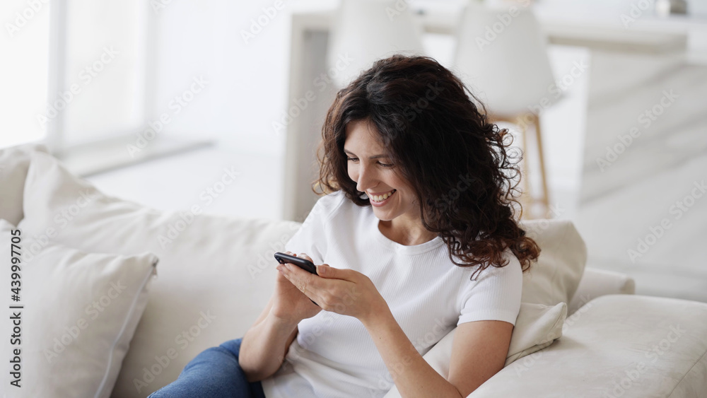 Woman with mobile phone home, beautiful brunette young happy model using smartphone Woman with mobile phone home, beautiful brunette young happy model using smartphone