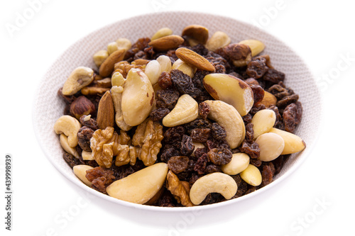 a mixture of chopped dried fruits and berries, nuts in a white dish on a white background.Isolated Products and items