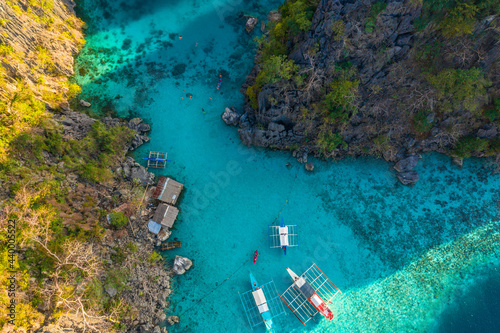 Tour boats by the shore at Coron island, Philippines. Fishermen boats by the sea aerial view.