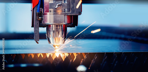 Blue color Laser CNC cut of metal with light spark, technology modern industrial banner