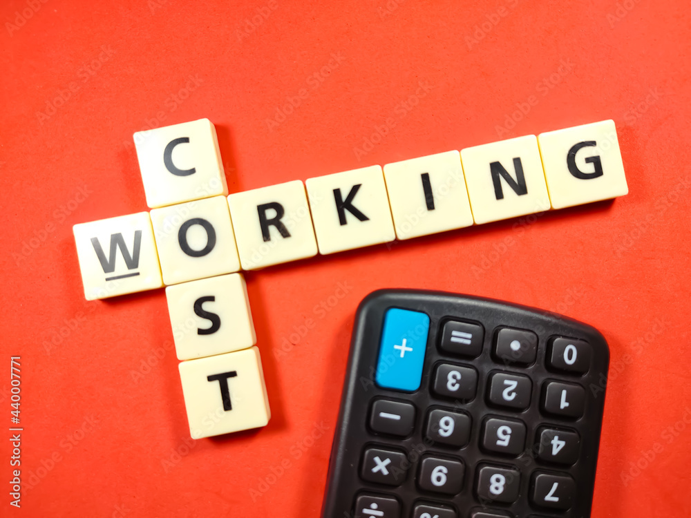 Selective focus.Scrabble letters with text COST WORKING and calculator on red background. Selective focus.Scrabble letters with text COST WORKING and calculator on red background.
