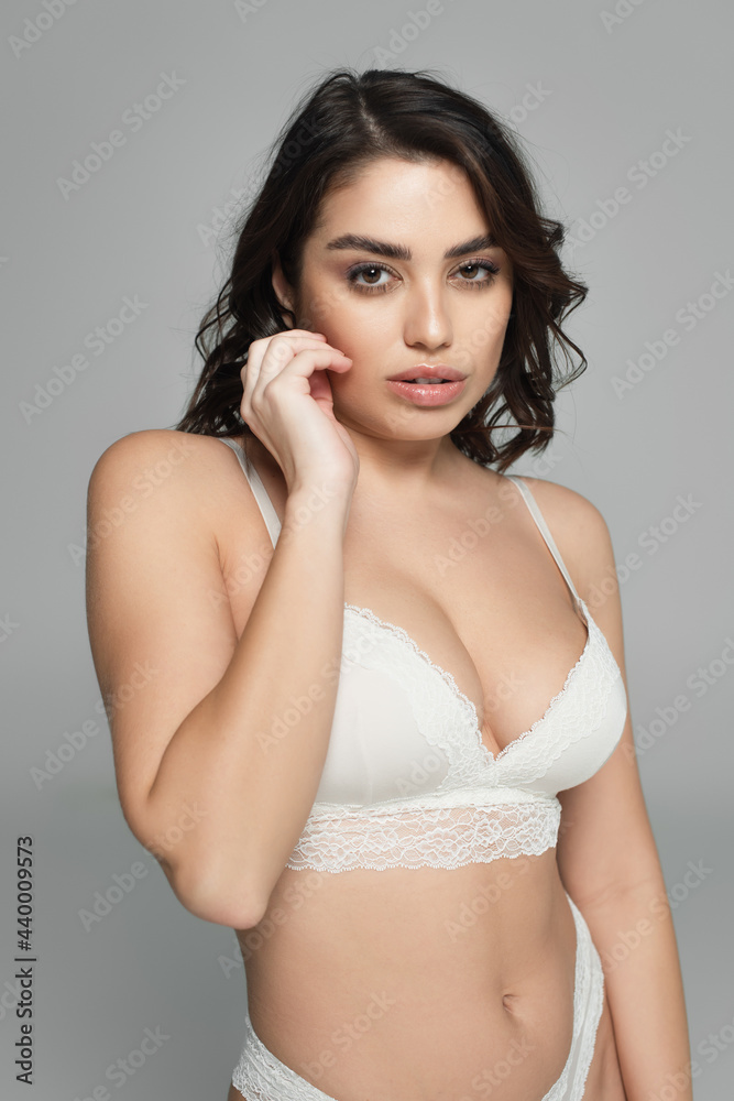 Portrait of sensual brunette woman looking at camera isolated on grey Portrait of sensual brunette woman looking at camera isolated on grey