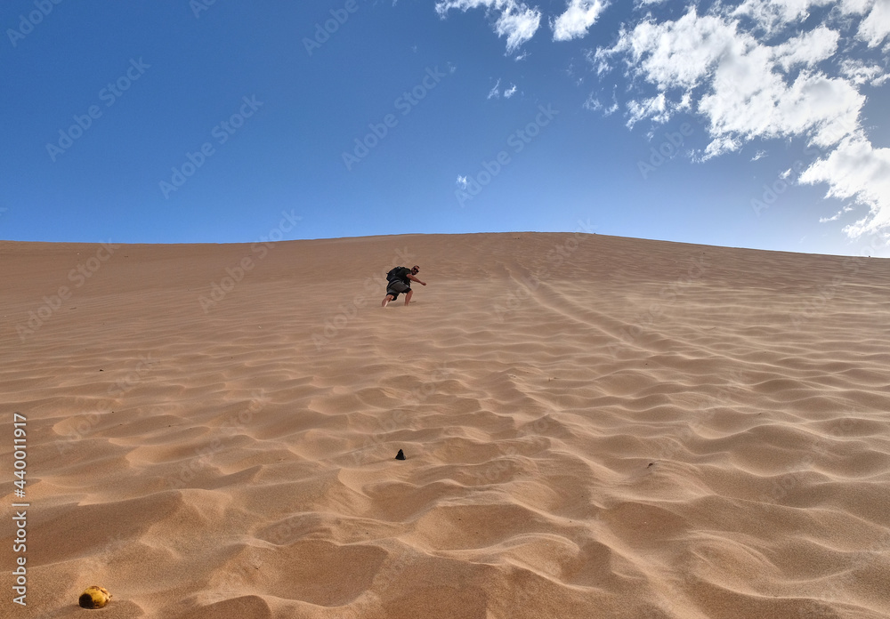 Young European tourist climbs Dune 7, Walvis Bay, Namibia