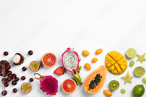 Fototapeta Naklejka Na Ścianę i Meble -  Many different delicious exotic fruits on white background, flat lay. Space for text