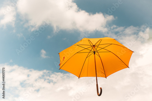 Yellow umbrella in the sky. Sunny umbrella in the sky, creating a summer, artistic mood on the street.