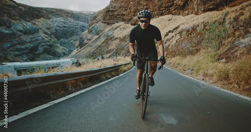 Road biker cycling on epic country road, intense workout and fitness, healthy active lifestyle
