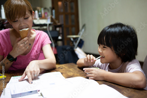 アイスを食べながら夏休みの宿題をする親子 photo