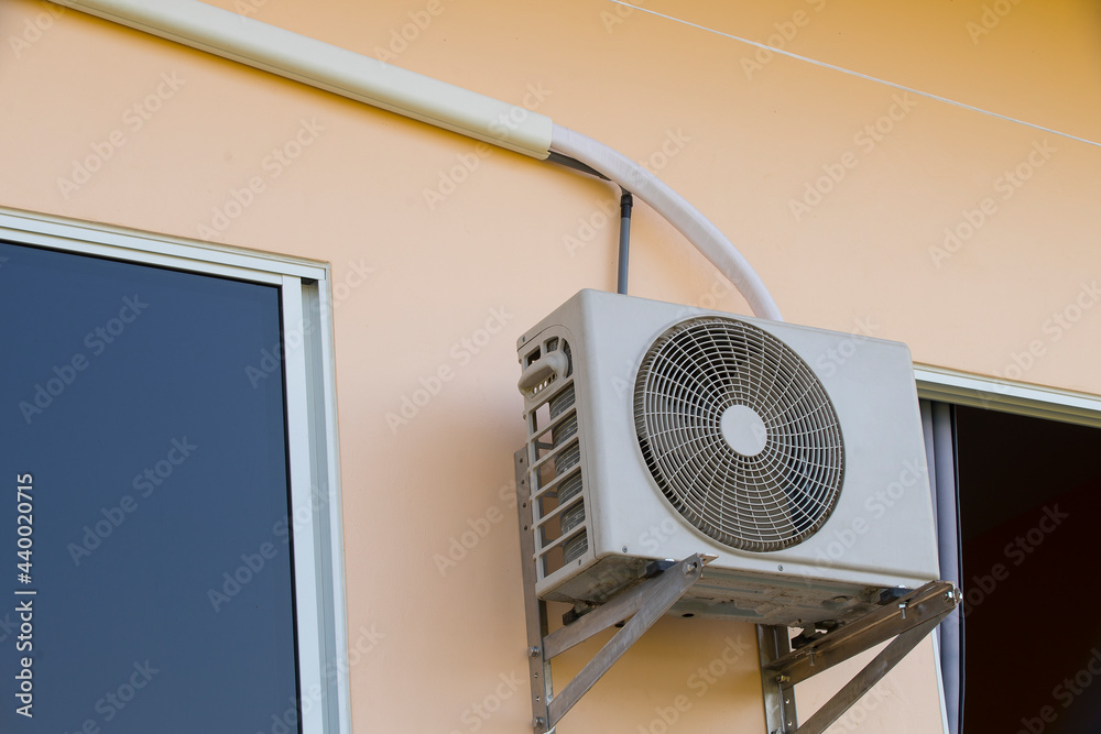 Square VAC Air Conditioning Unit on wall house with a round fan. Stock