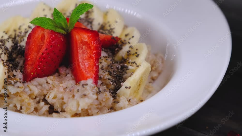 Healthy breakfast of oatmeal bananas and strawberries and chia seeds in a white plate Healthy breakfast of oatmeal bananas and strawberries and chia seeds in a white plate