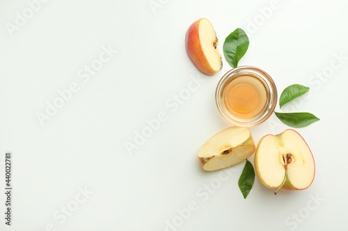 Homemade apple vinegar and ingredients on white background