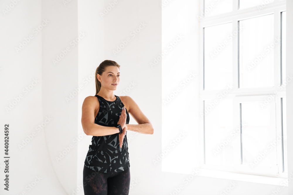 Young white woman doing exercise during yoga practice indoors Young white woman doing exercise during yoga practice indoors