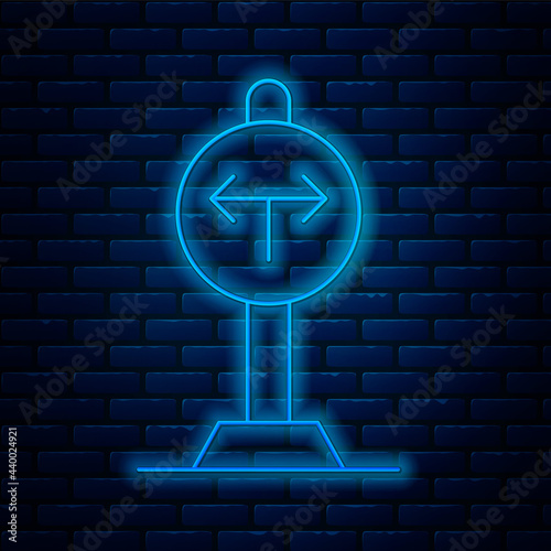 Glowing neon line Fork in the road icon isolated on brick wall background. Vector